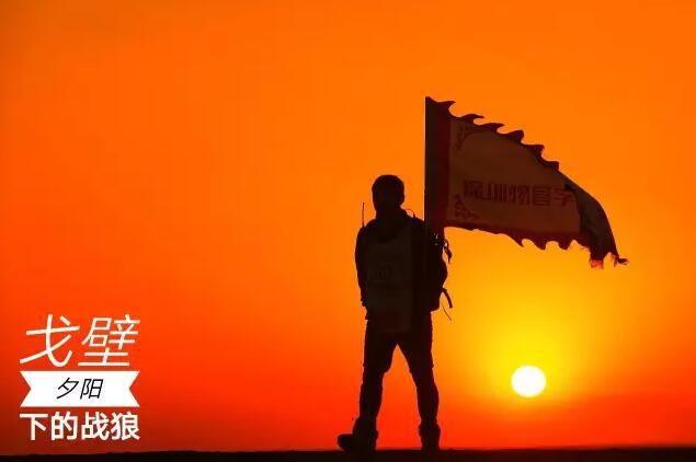 林琅部长举起中国物业管理精英戈壁徒步挑战赛的深圳物管学院队旗帜